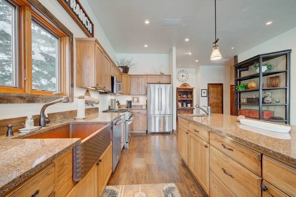 The kitchen includes a large island with seating and a prep sink. 