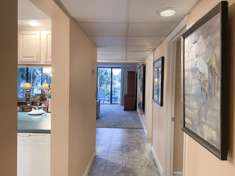 Off of the hallway is the kitchen, guest bathroom, guest bedroom and living space.