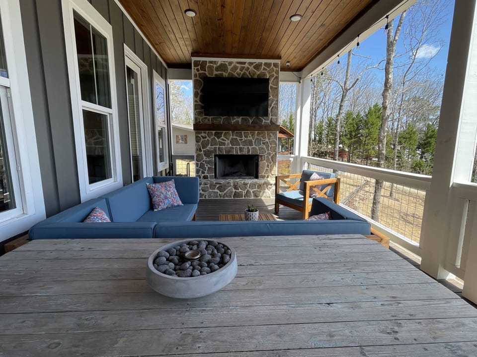 Upstairs outdoor seating area and wood-burning fireplace with propane starter.