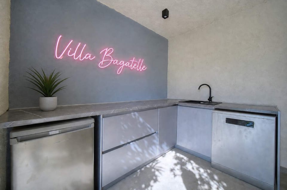 Practical summer kitchen located on the pool level, just a few steps below the main living area. Equipped with a sink, dishwasher, fridge and countertop space, it makes outdoor meals and drinks by the pool easy and convenient.