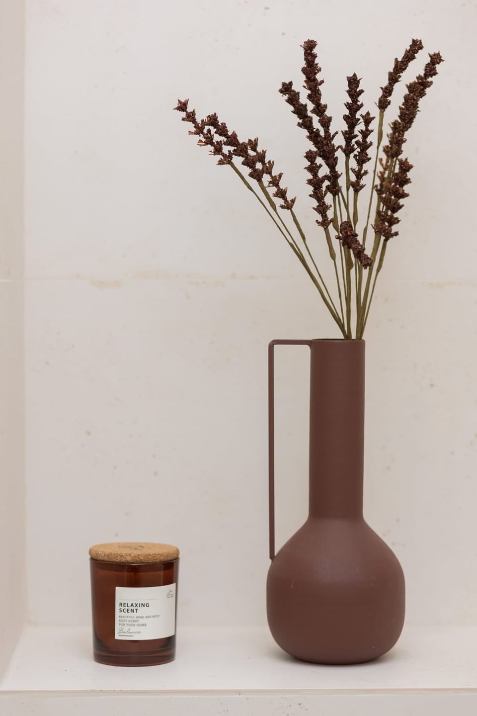 A minimalist vase with decorative branches, complementing the room's elegant design.
