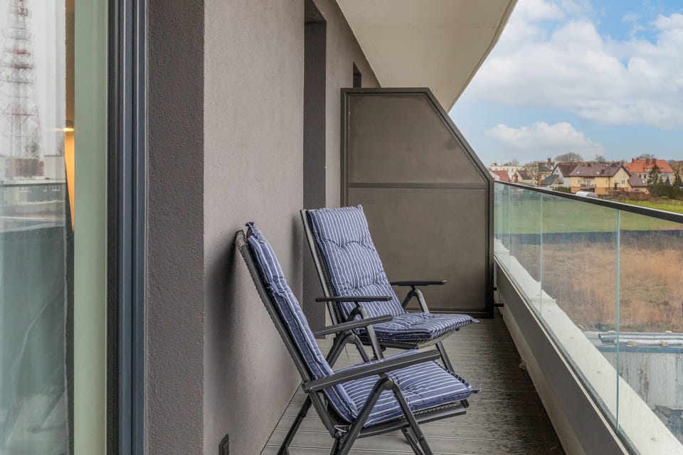 A balcony view with outdoor seating overlooking the cityscape.

