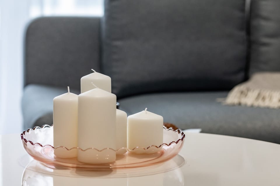 A tray with pastel-colored candles and a soft decor accent.

