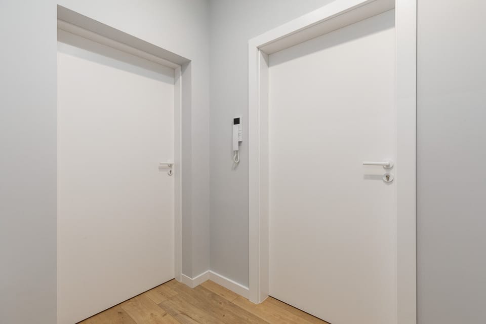Hallway with two white doors, providing access to other rooms.
