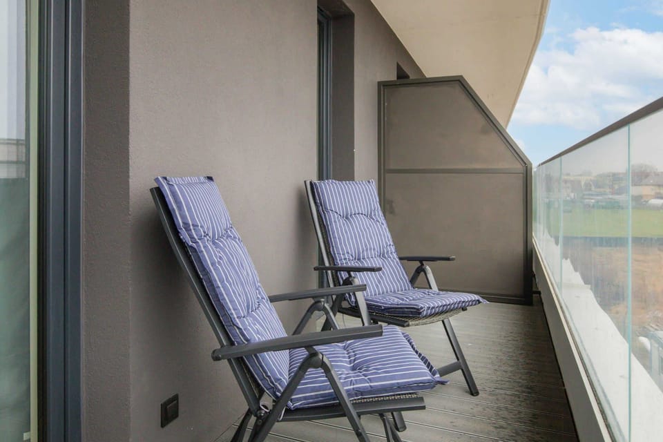 Balcony with two lounge chairs and a scenic view of the outdoors.

