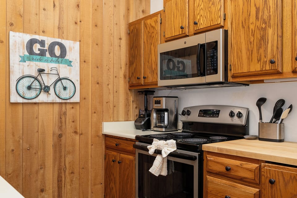 Your rustic kitchen awaits with warm wood cabinetry and all the essentials for preparing meals during your mountain getaway.