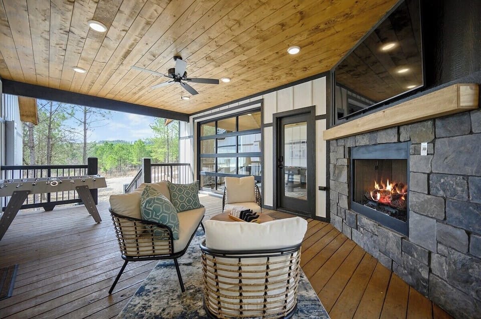 The glass panel garage door can be opened or closed. Grab some bean bags for a game of cornhole, challenge someone to a game of foosball, or open the garage to bring the pool table to the party. The breezeway offers many options for covered outdoor fun, all while looking over the beautiful pines.
