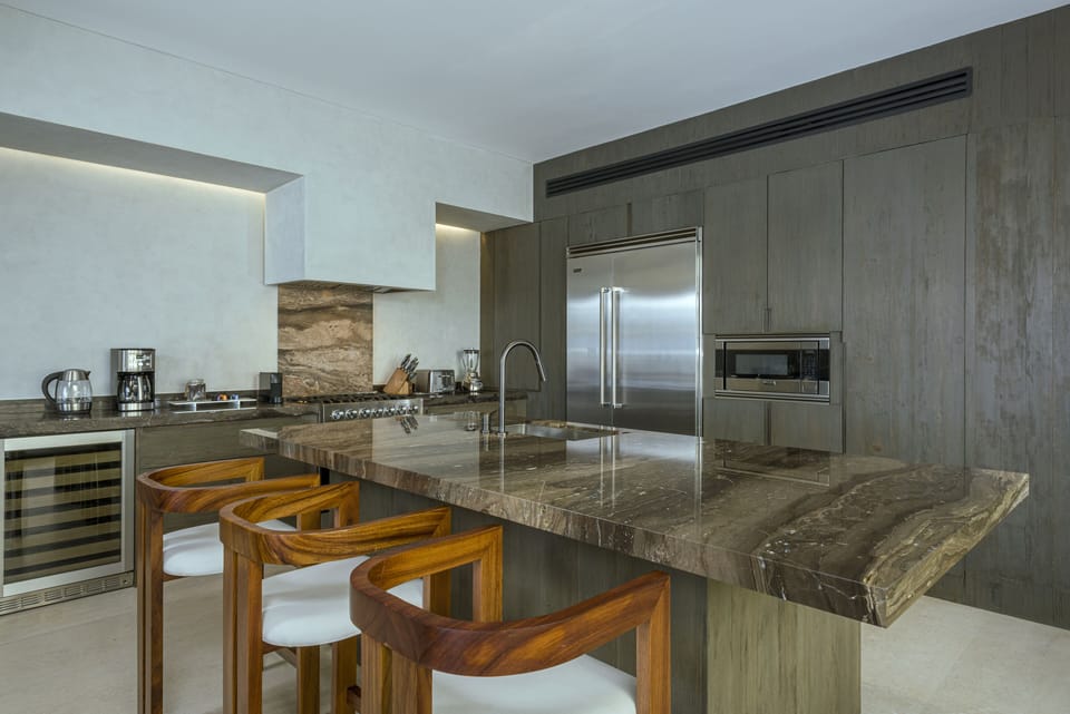 Gourmet kitchen with a marble island and stainless appliances at Villa Marena in Hacienda Beach, Cabo San Lucas.