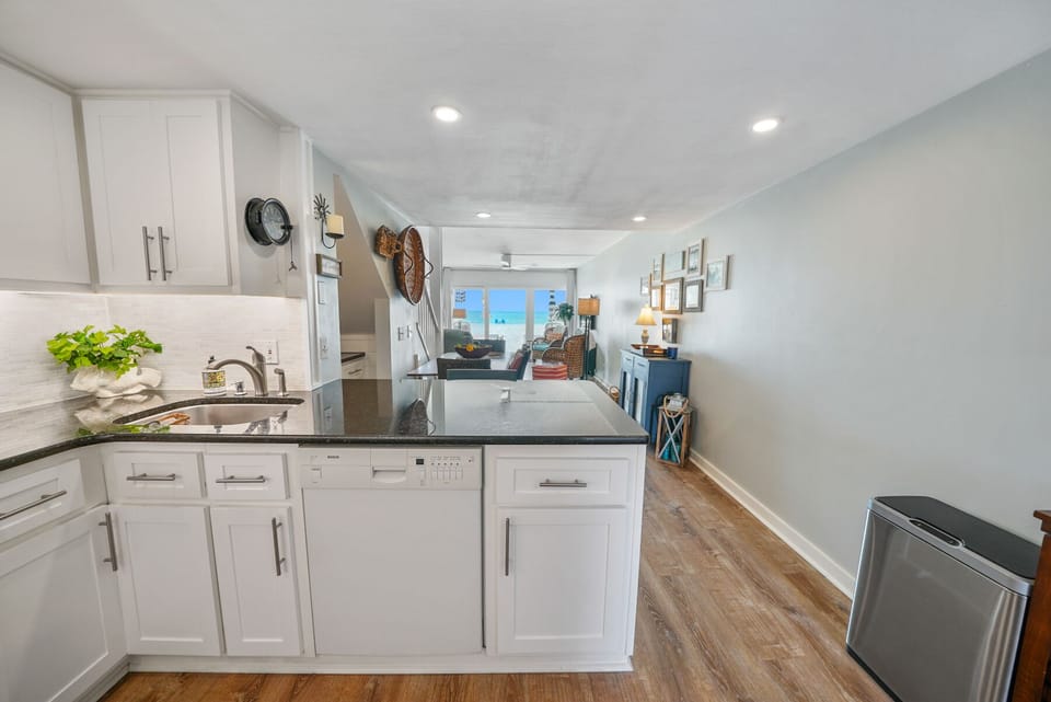 Your modern kitchen opens beautifully to the living space, featuring pristine white cabinets, sleek countertops, and everything you need to create memorable meals.