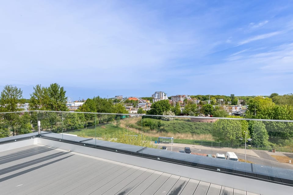 A scenic rooftop view overlooking greenery and the horizon.

