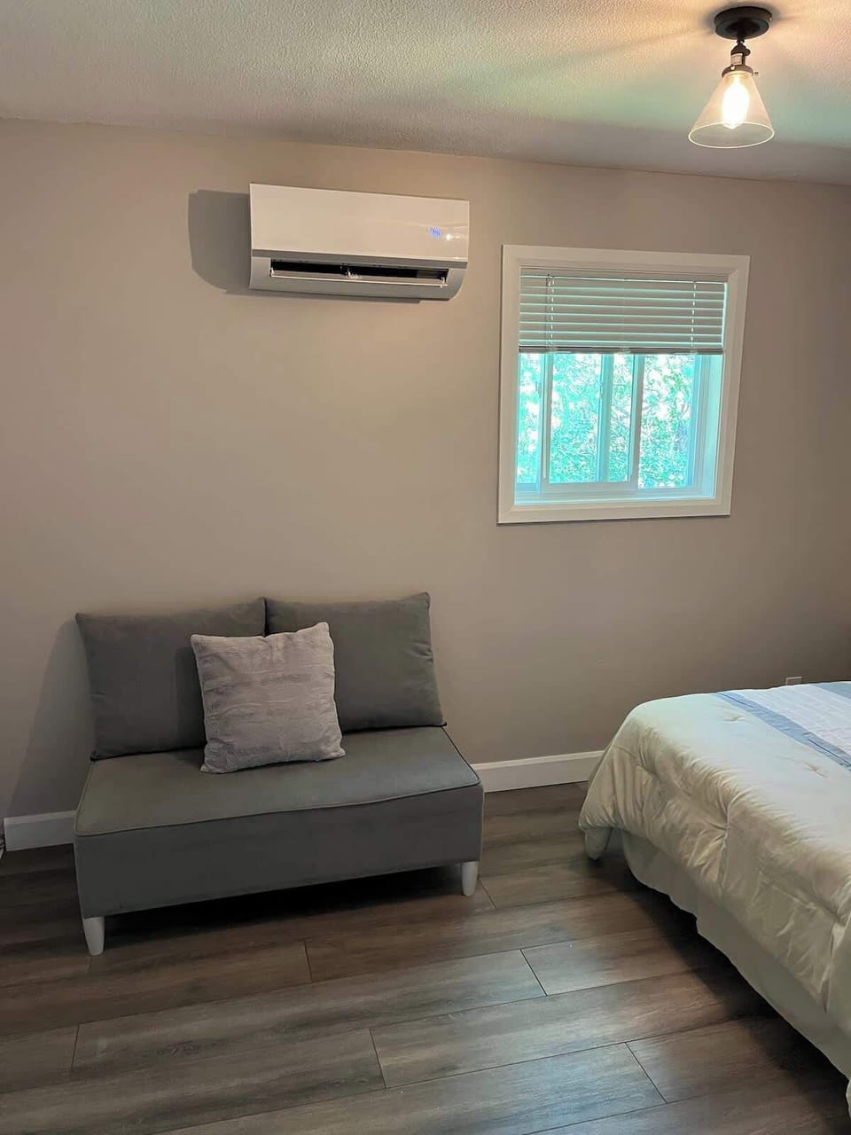 Bedroom featuring a warm queen size bed and a comfy couch
