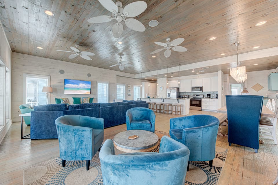 You'll love gathering in this stunning open-concept space with coastal blues, rustic wood ceilings, and modern amenities flowing seamlessly together.