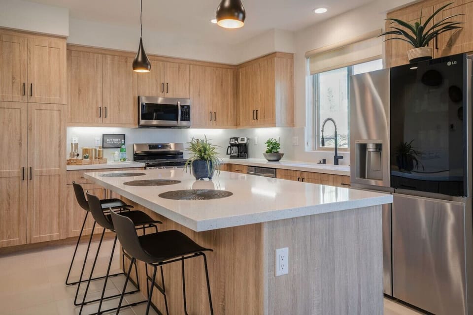 Modern kitchen w/ island seating, sleek finishes & stainless appliances