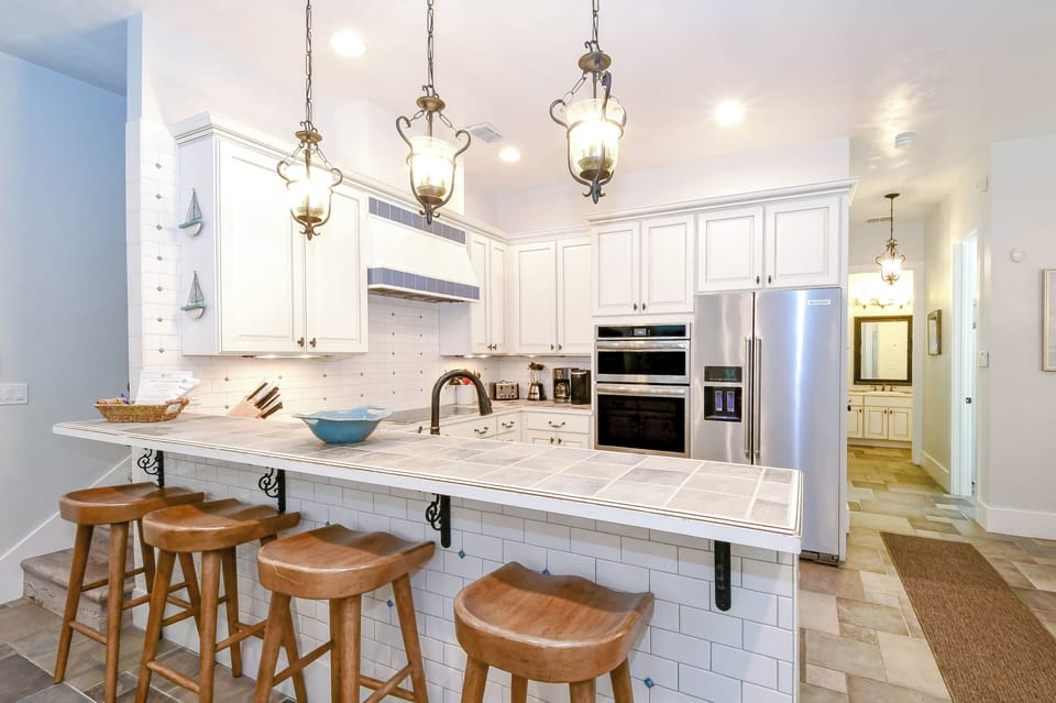 Your gourmet kitchen awaits with marble countertops, elegant pendant lighting, and a breakfast bar perfect for morning coffee conversations.