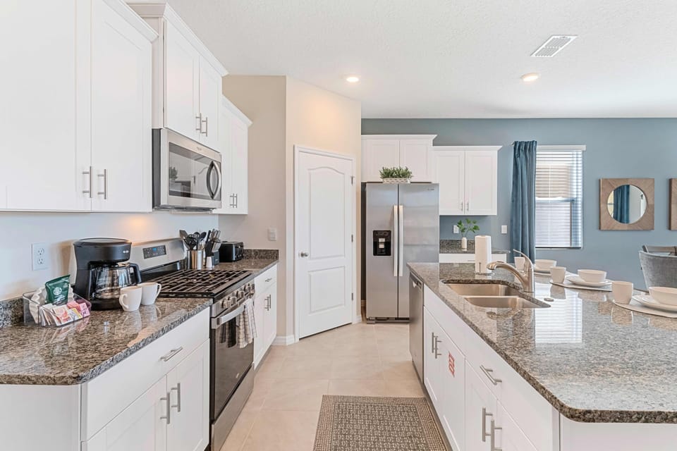 Polished kitchen of the home in Davenport Florida - Deluxe Stainless Steel Appliances - Plenty storage space for organized and clutter-free counters - Sufficient space to walk and work according to your ease