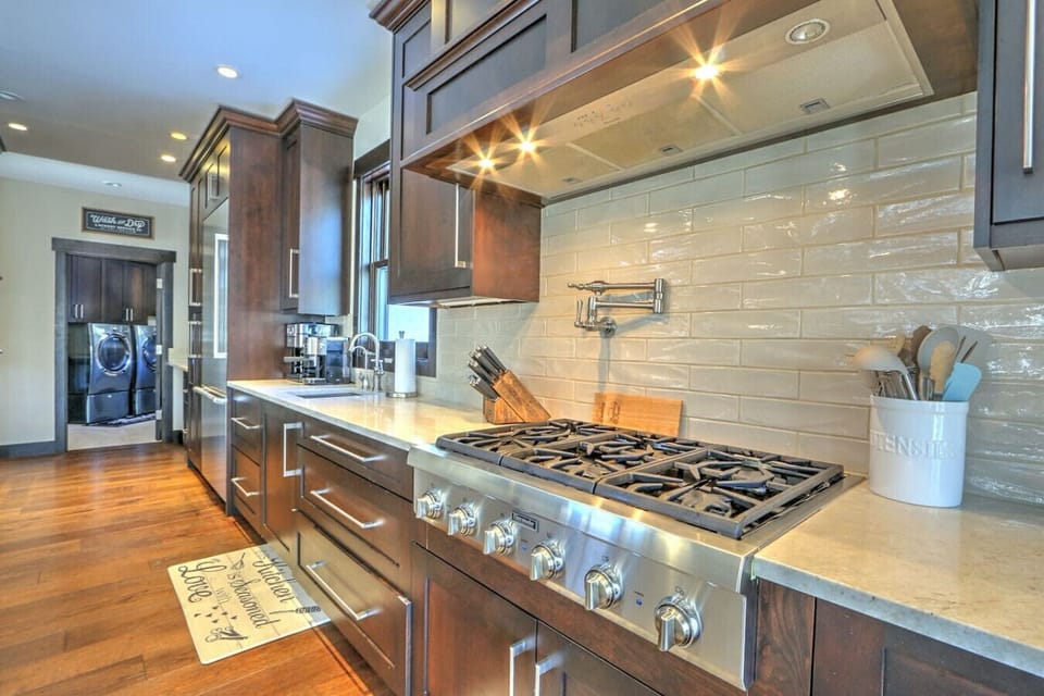 Pristine chef`s kitchen w/ luxury range and hall to laundry & mudroom
