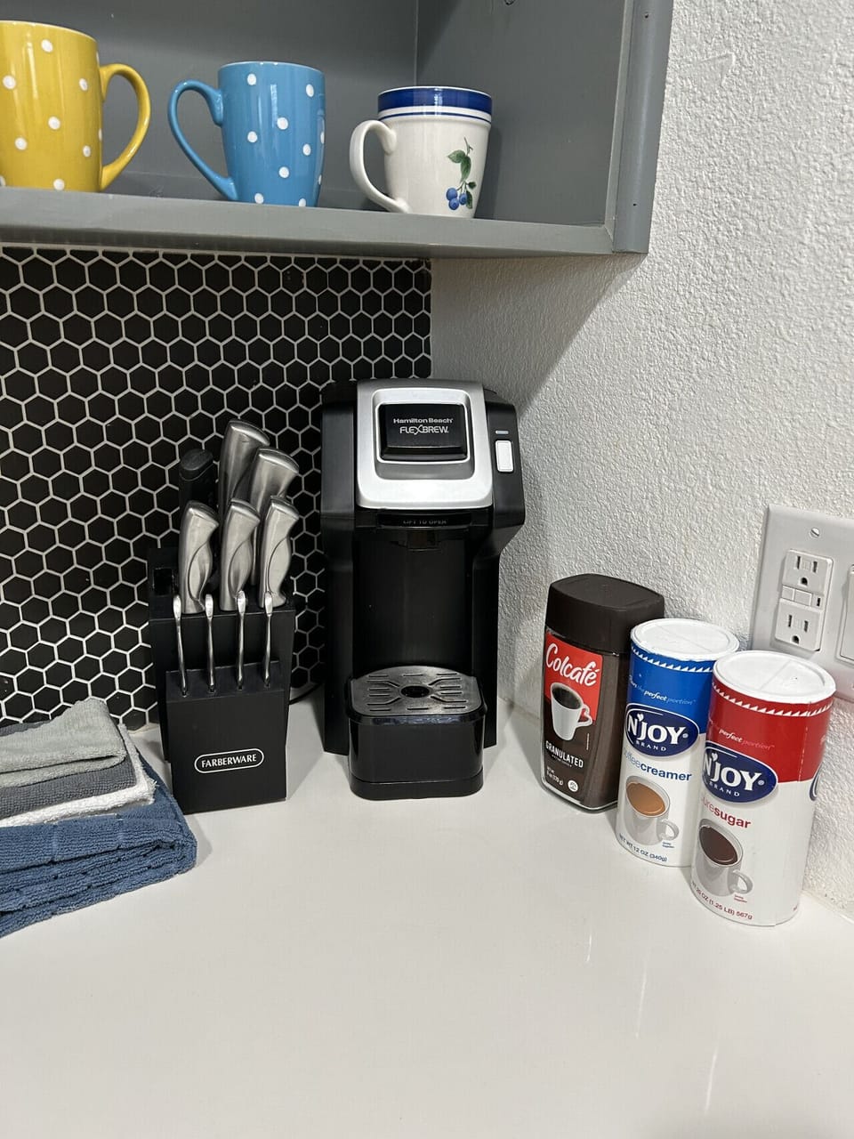 Knives, keurig, coffee, creme and sugar.