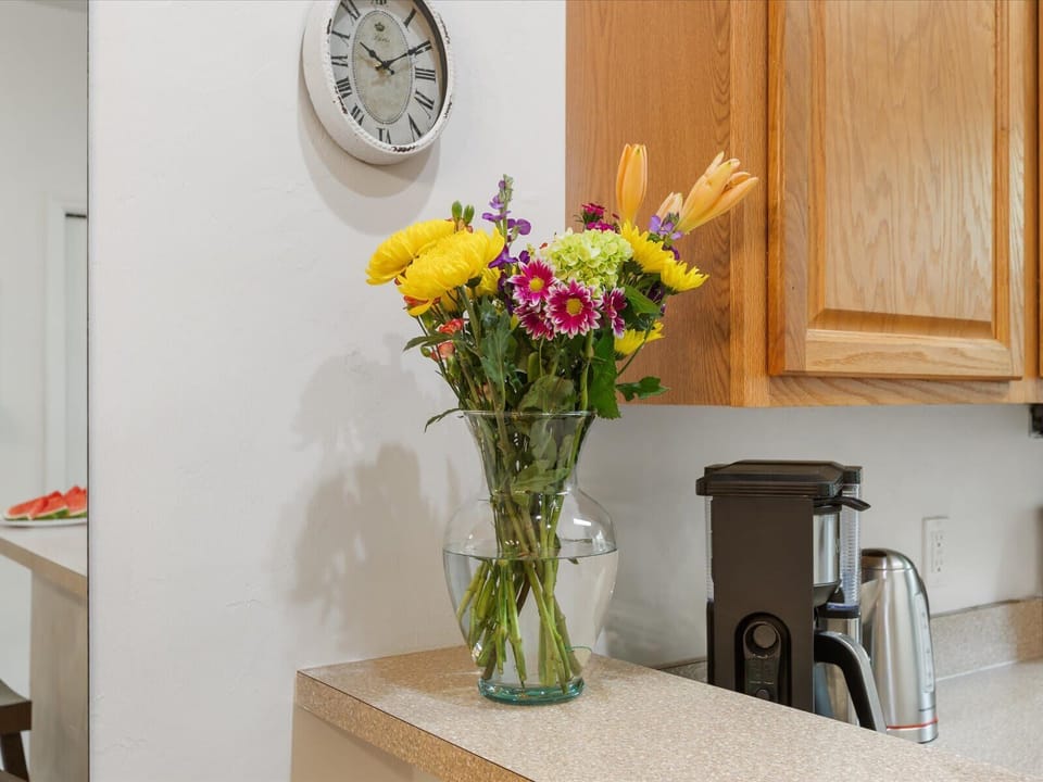 Bright and cheerful kitchen corner with coffee essentials and a fresh bouquet to brighten your stay.