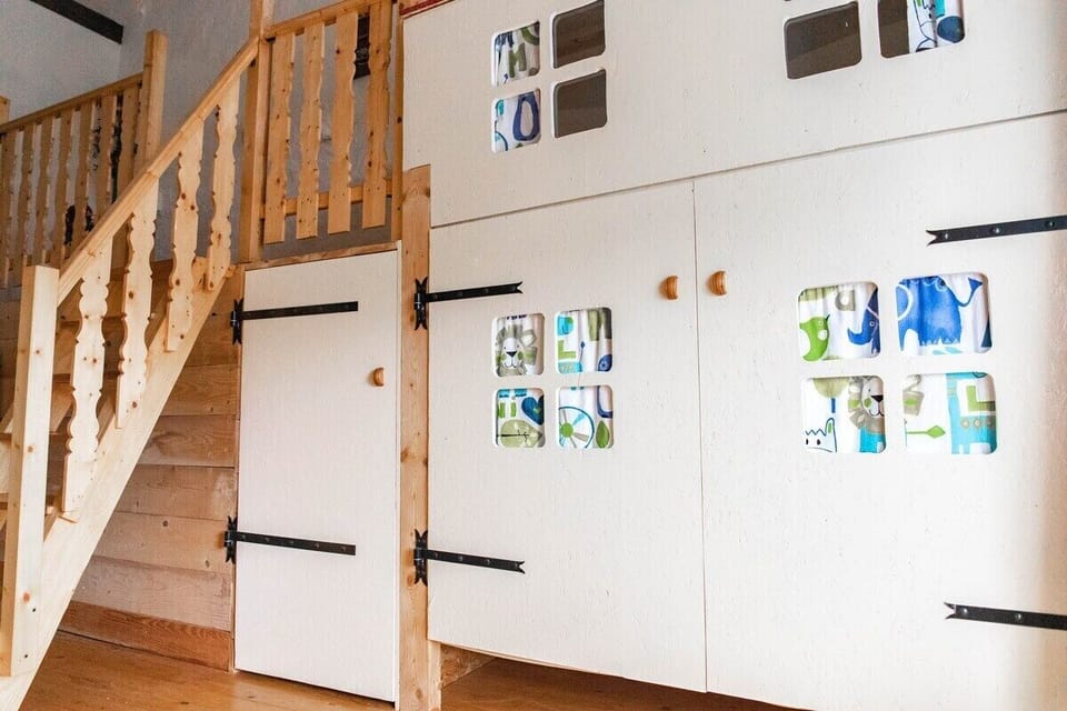 Upstairs landing with a cupboard filled with childrens toys, and a bunk bed.