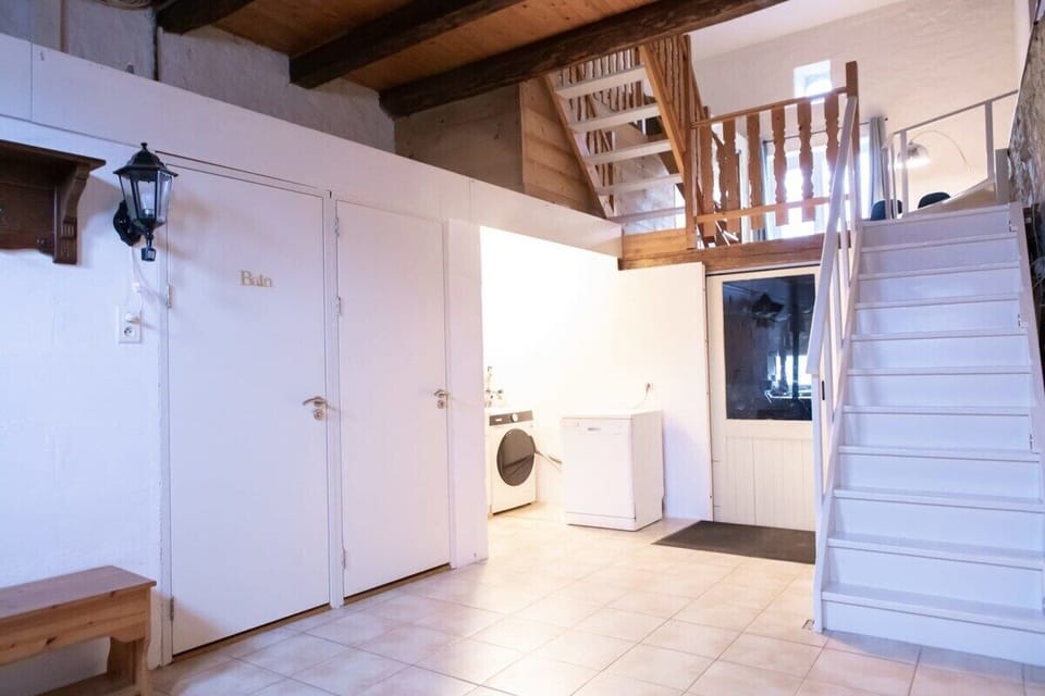 Downstairs hallway with washing machine and dishwasher. Access to the downstairs toilet and bathroom, as well as the workshop with the sauna.