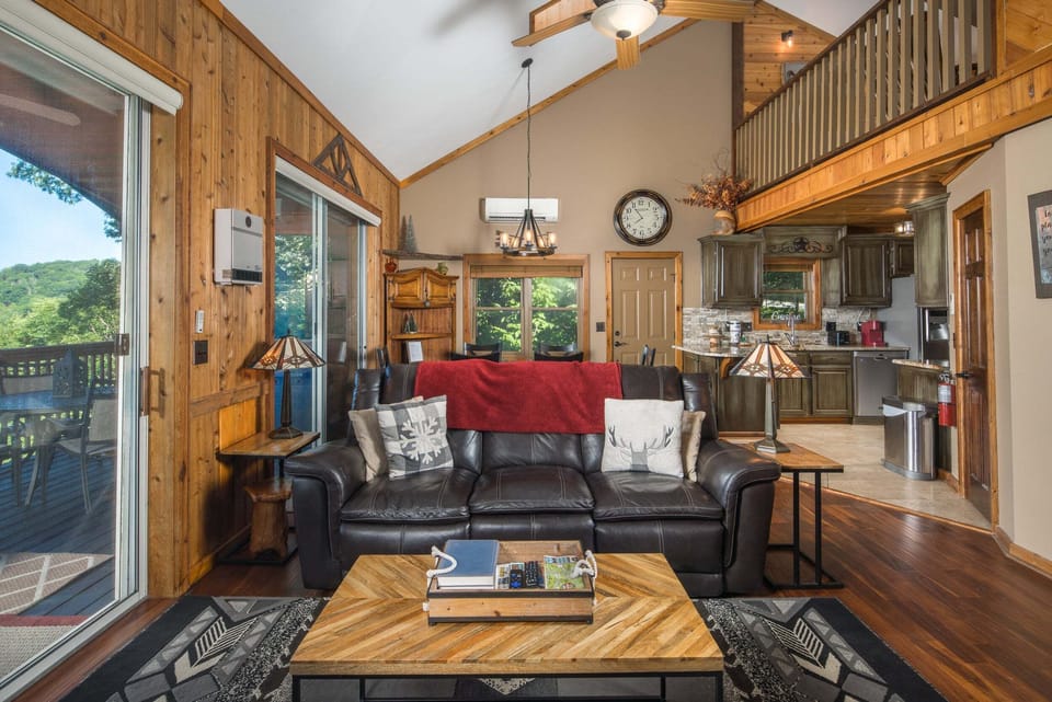 Open-concept living room, dining area, and loft with mountain views throughout