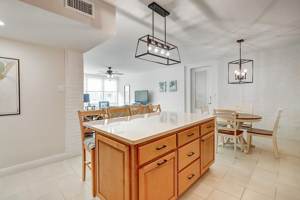 Gather around your spacious kitchen island for meals and conversation in this bright, open-concept space with elegant pendant lighting.