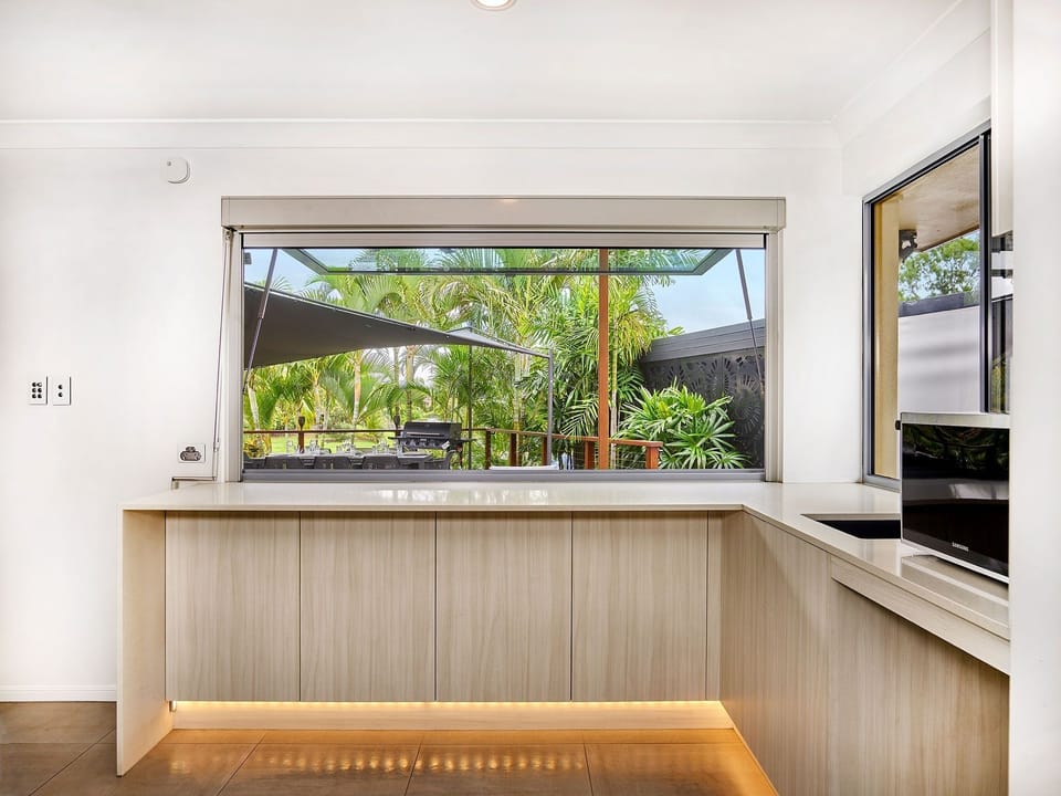 Fully equipped modern open-plan kitchen with full-size fridge, oven, stovetop.