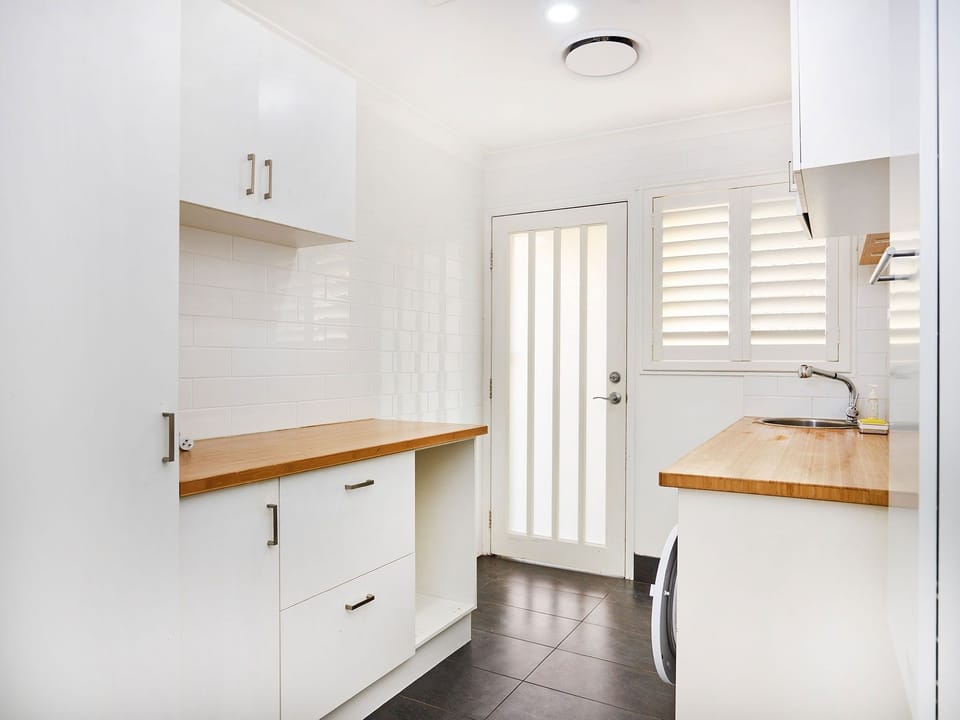 Fully equipped modern open-plan kitchen with full-size fridge, oven, stovetop.