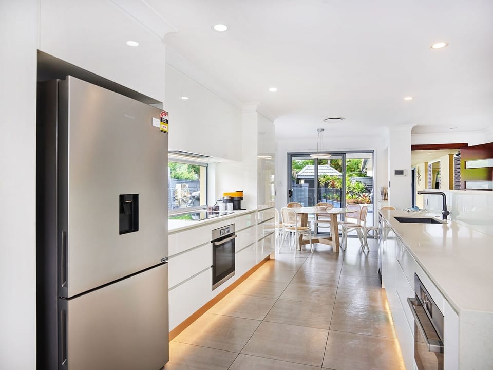 Fully equipped modern open-plan kitchen with full-size fridge, oven, stovetop.