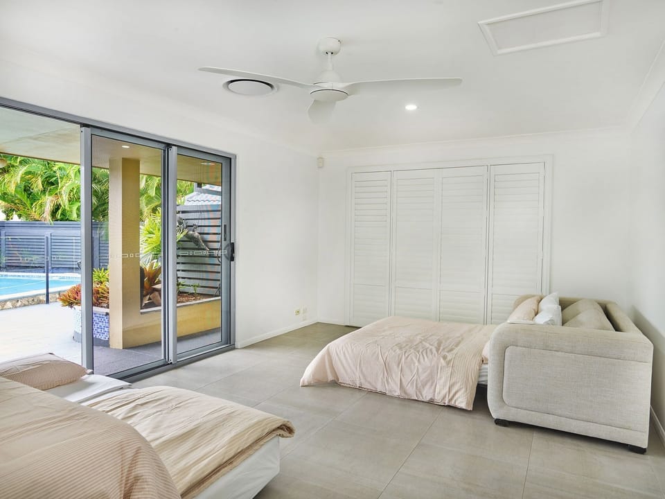 Open-plan living with sofa and ceiling fan.