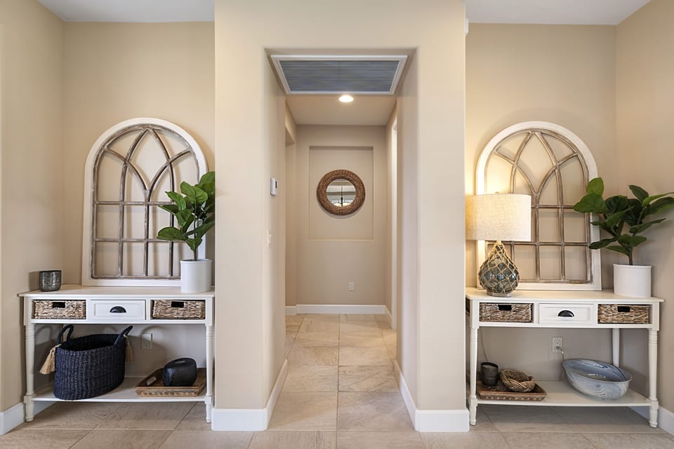 Bright interior hallway with decorative shelving and clean island-inspired design.