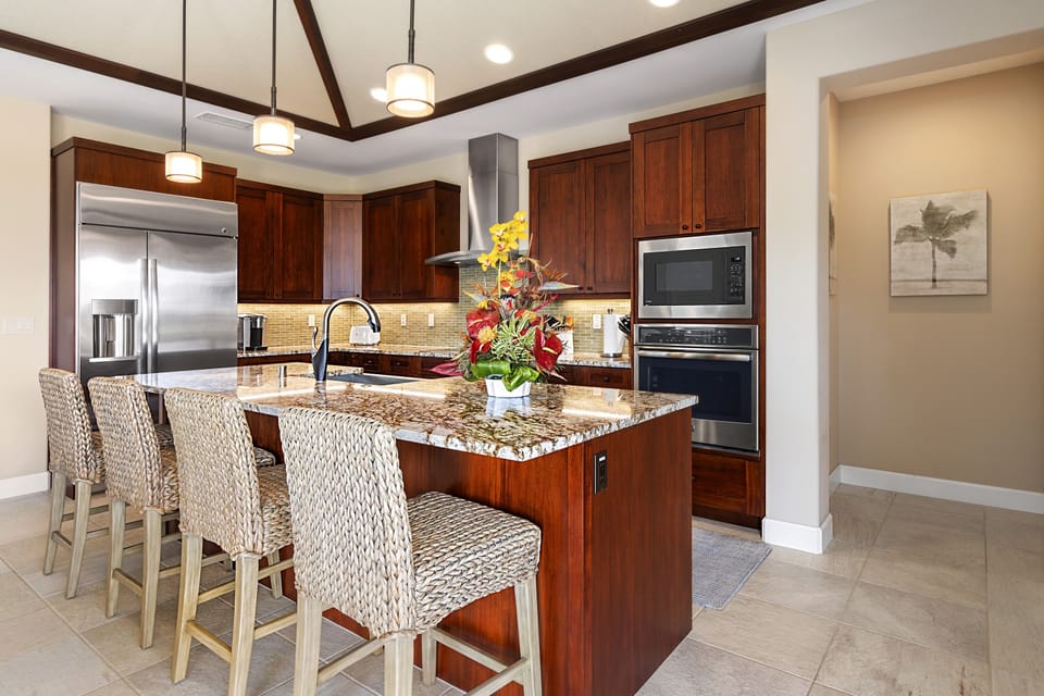 Spacious kitchen with granite island, bar seating, and rich wood cabinetry.