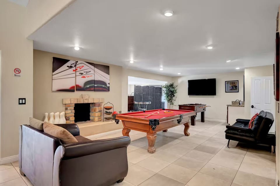 Game room with pool table that can be converted to ping pong table, foosball tab