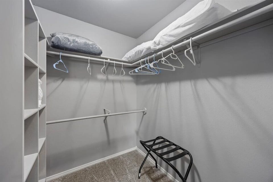 Master closet with extra bedding, storage and luggage rack
