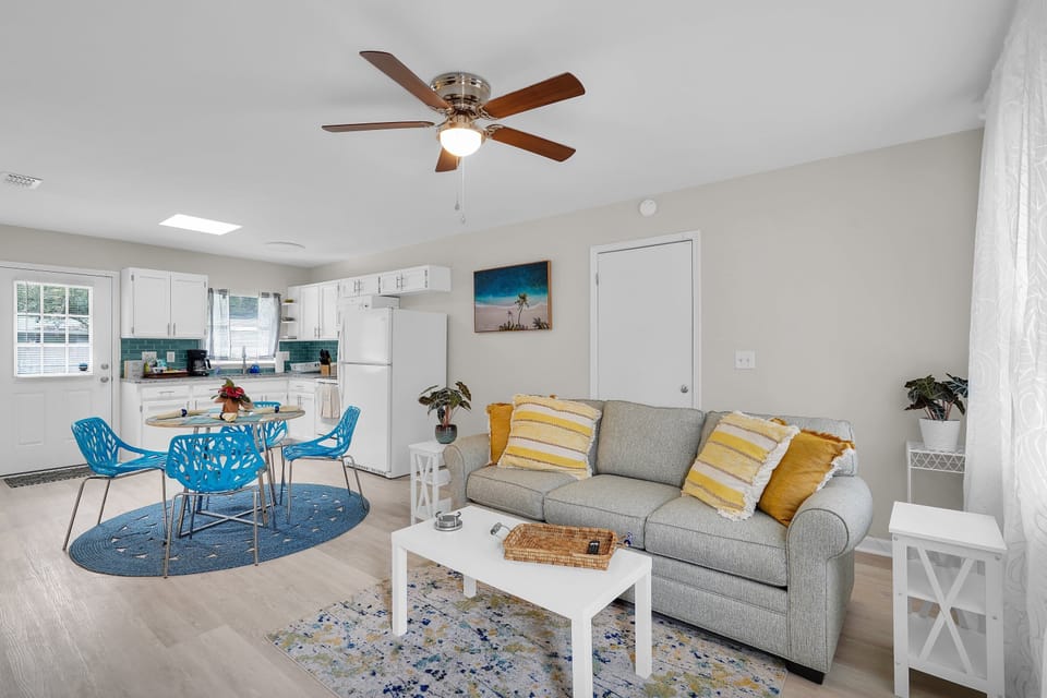 Modern, airy living space and dining room with blue accents and clean design.