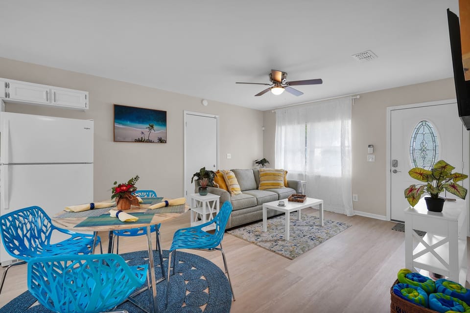 Modern, airy living space and dining room with blue accents and clean design.