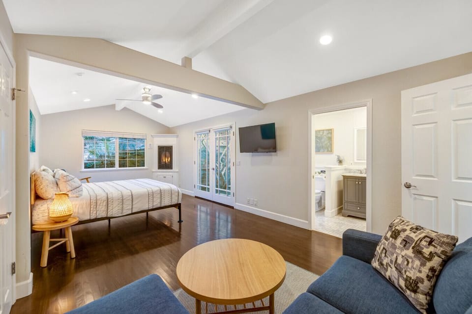 En-suite primary bedroom with seating area, fireplace, walk-in closet, and rocking chair.