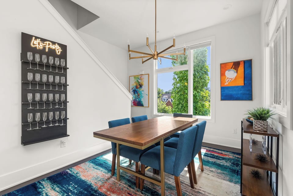 - Colorful dining area with modern art and bright natural light   - Trendy seating perfect for meals and celebrations   - Fun wall display adds a playful touch to your stay