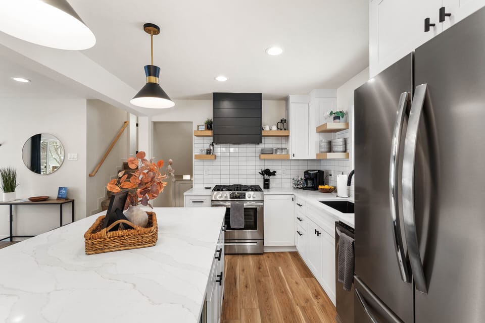 Fully equipped kitchen with gas stove, dish washer, refrigerator, and microwave.