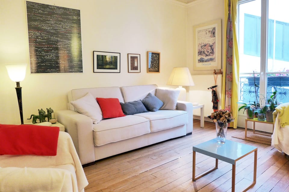 The living room bathes in natural light and offers a comfortable, cozy sofa bed