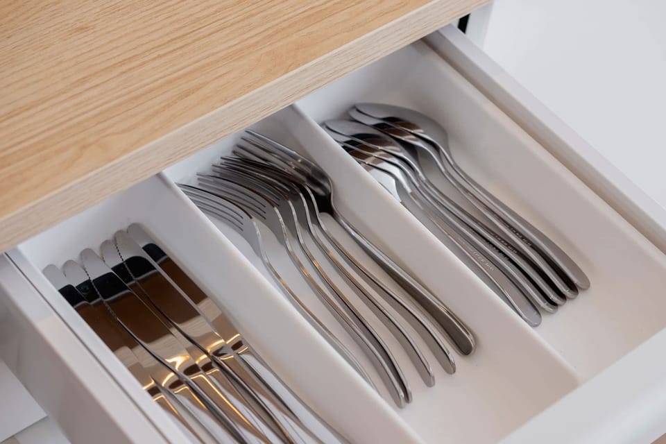 A close-up of a drawer neatly organized with cutlery, emphasizing attention to detail.
