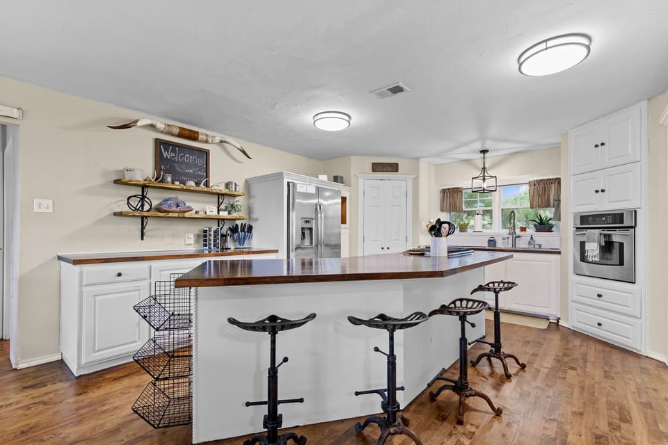 The open concept kitchen has four barstools.
