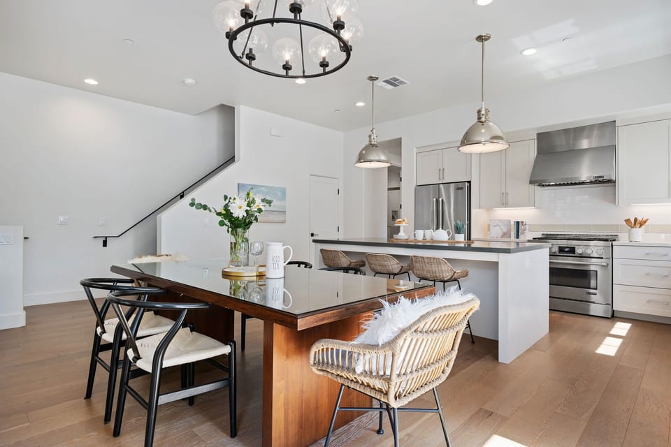 Dining table with seating for six adjacent to the kitchen and kitchen island