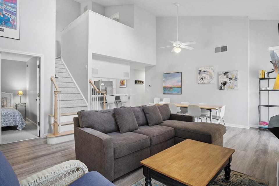 54021 Sand Dollar Court -seating area - Wide-angle view showing the seamless transition from the living room to the dining area, featuring a loft overlook and clean white walls.