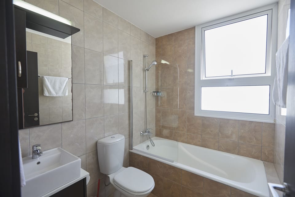 Main Bathroom with bathtub, overhead shower and WC