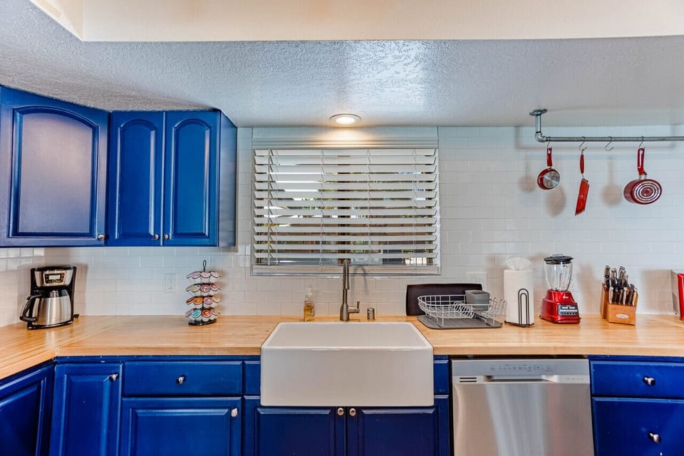 kitchen with a farmhouse sink and bold blue cabinets.