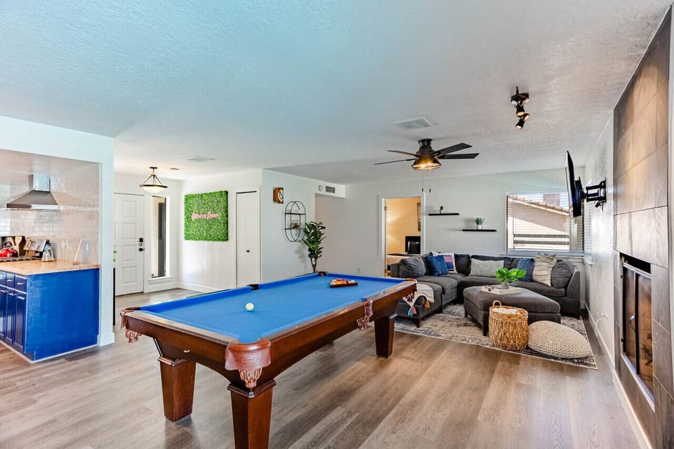 A pool table, cozy sectional sofa, and a warm fireplace