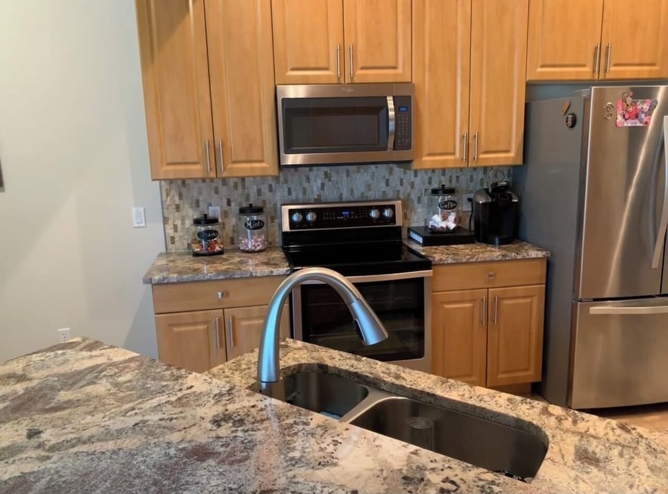 Stainless steel appliances, granite countertops, stone backsplash 