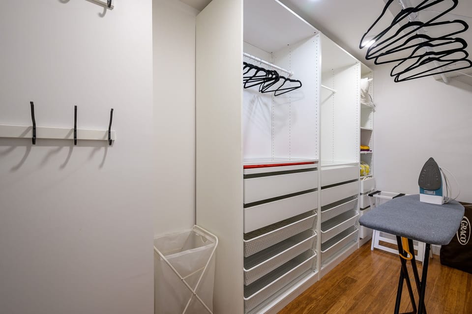 The walk in closet offers plenty of clothes storage and an iron with ironing board.