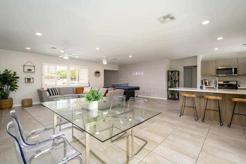 The dining table seats up to 4 guests, with additional barstool seating nearby.